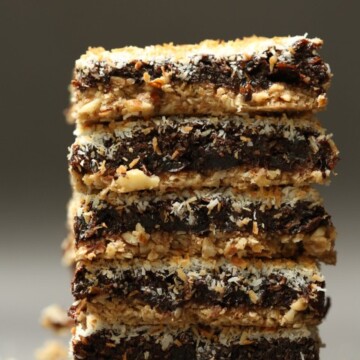 A close up image of a stack of chocolate, prune and coconut squares