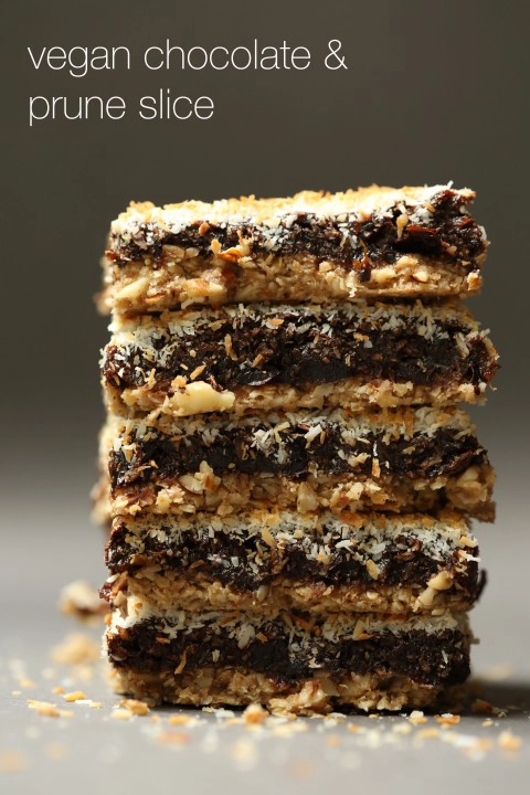 A close up image of a stack of chocolate, prune and coconut squares