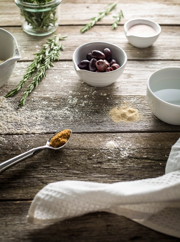 Olive bread ingredients laid out on a wooden table top