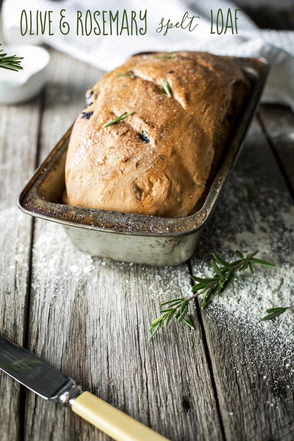 A homemade loaf of bread in a vintage bread pan on a wooden bench