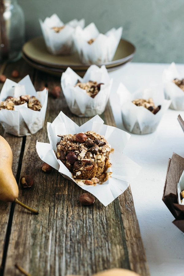 Vegan hazelnut pear and chocolate muffins are sweetened with pears, lavished with dark chocolate buttons & topped with toasted hazelnut chocolate streusel.