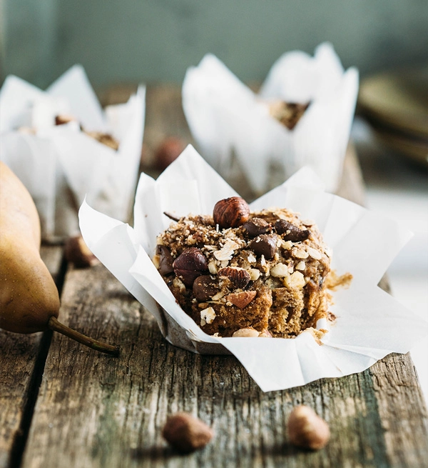 Vegan hazelnut pear and chocolate muffins are sweetened with pears, lavished with dark chocolate buttons & topped with toasted hazelnut chocolate streusel.
