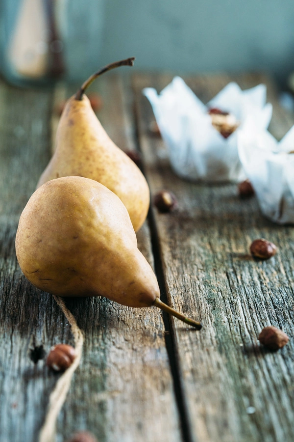 Vegan hazelnut pear and chocolate muffins are sweetened with pears, lavished with dark chocolate buttons & topped with toasted hazelnut chocolate streusel.