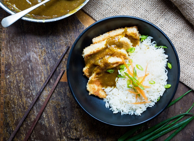 An overhead image of the finished Japanese tofu curry with white rice, scallions and sliced carrot