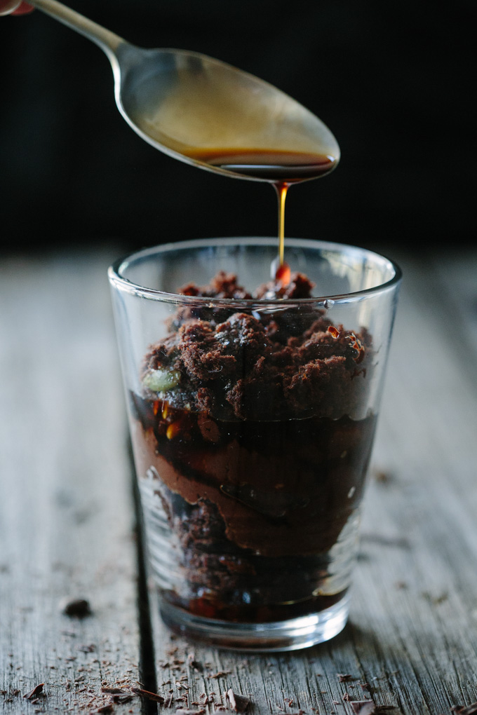 A process image of the coffee syrup being poured over a layer of brownie in a glass