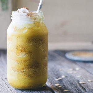 A jar of frozen golden latte with a straw