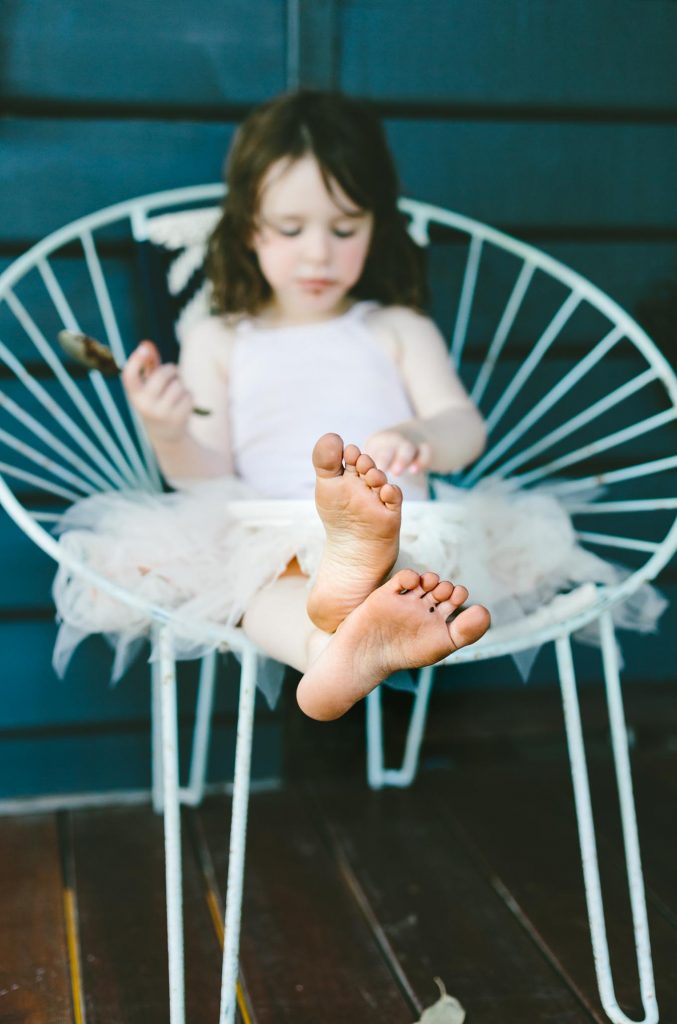 A little girl sitting on a chair eating cake