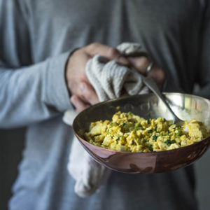 An image of a man holding a skillet of scrambled tofu