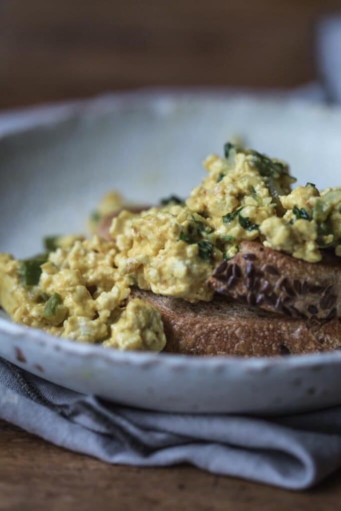 Close up of plate of scrambled tofu on toast in white bowl