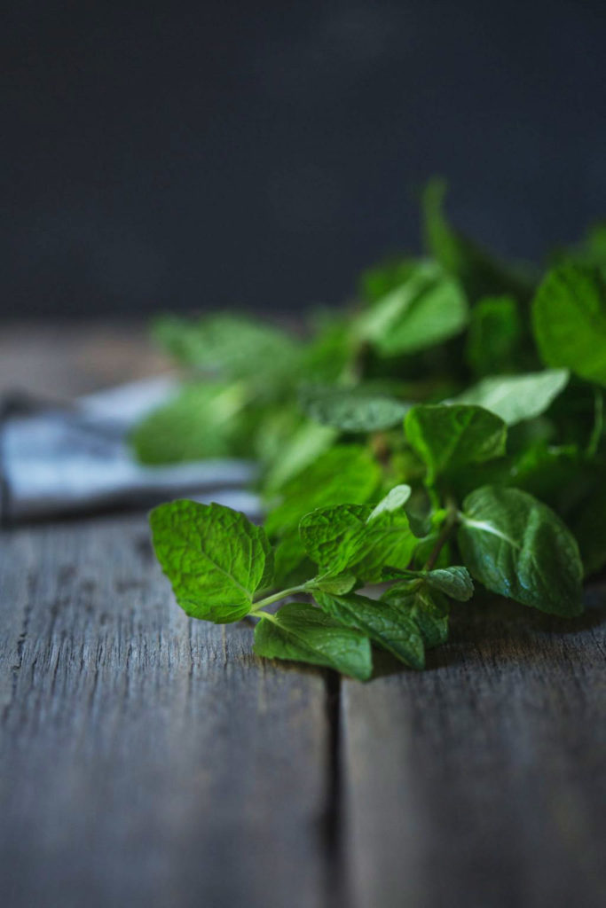 Close up image of freshly picked mint on a rustic wooden bench