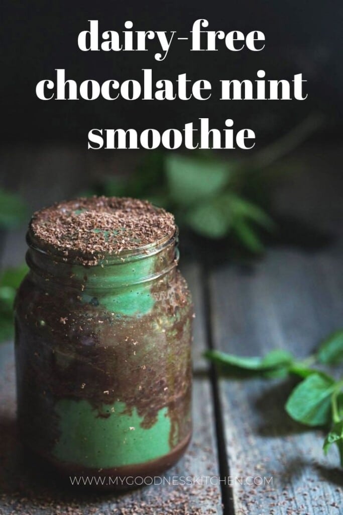 A close-up front on image of a large jar of the finished dairy-free chocolate mint smooth with chocolate ripples and dark chocolate shavings on top sitting on a rustic wooden bench with fresh mint scattered around. Title text overlay in white. 