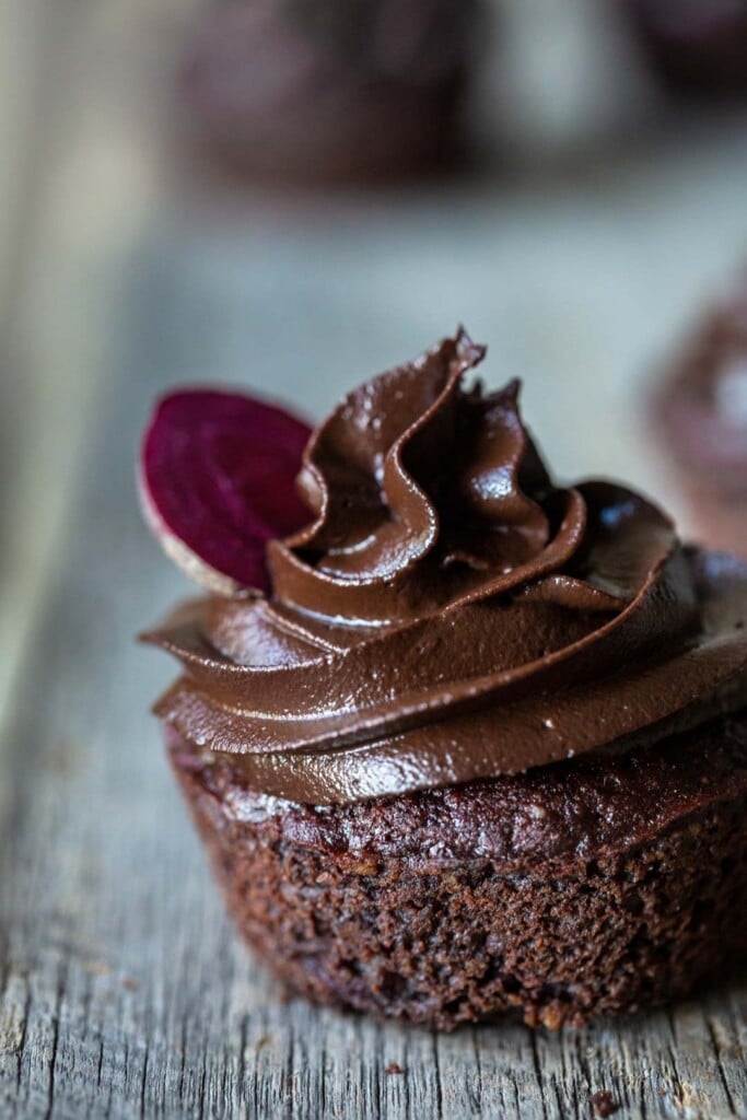 Super close-up image of a single vegan chocolate beetroot cake freshly iced with a chocolate avocado frosting swirl