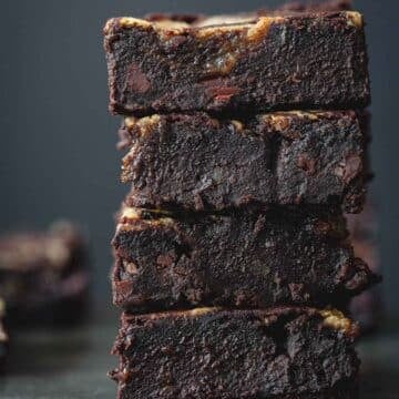 Black bean brownie squares stacked on top of each other.