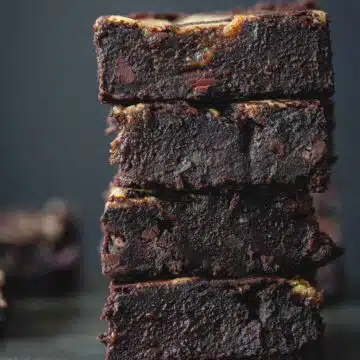 Black bean brownie squares stacked on top of each other.