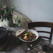 Potato and lentil stew in a white bowl on a rustic table setting.