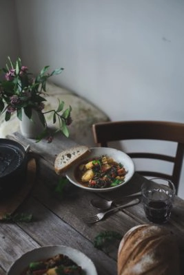 Potato and lentil stew in a white bowl on a rustic table setting.
