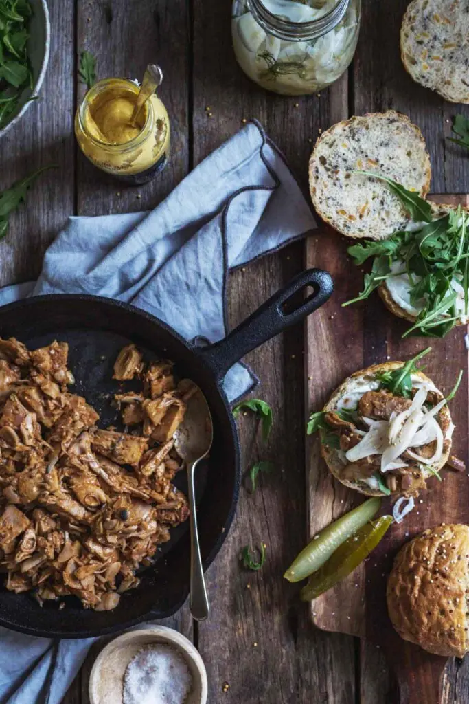 Overhead image of easy Creole jackfruit burgers being assembled on a rustic wooden bench