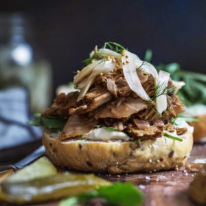 A close up image of a jackfruit burger on a wooden board.