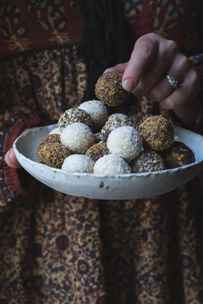 woman holding a bowl of vegan truffles