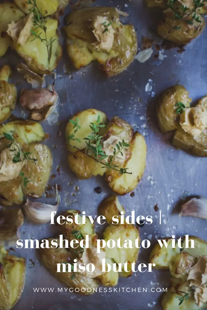 An overhead image of roasted smashed potatoes with herbs with text. 