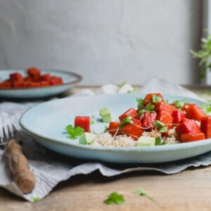 A watermelon salad in a light blue bowl.