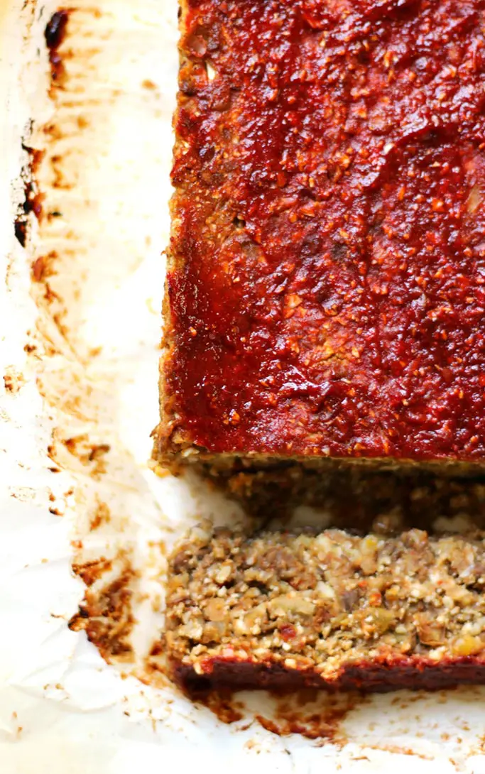 A close up overhead shot of vegan lentil cauliflower loaf on white paper