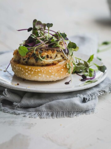 A close up image of a cauliflower burger on a white plate.