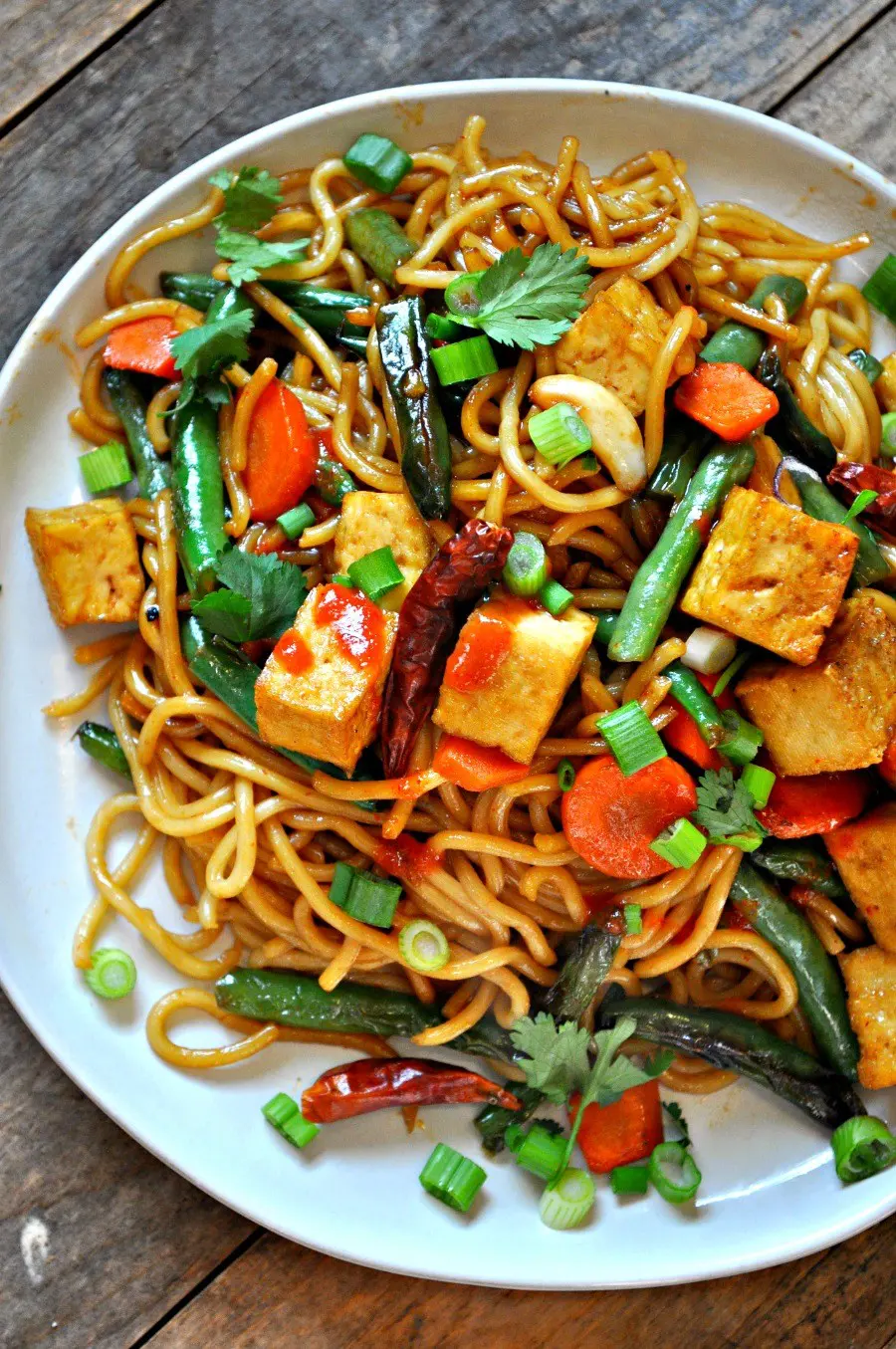 A white bowl of vegan garlic sriracha tofu yakisoba