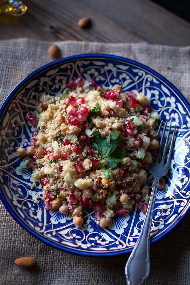 A blue bowl with couscous, almond, chickpeas and pomegrante