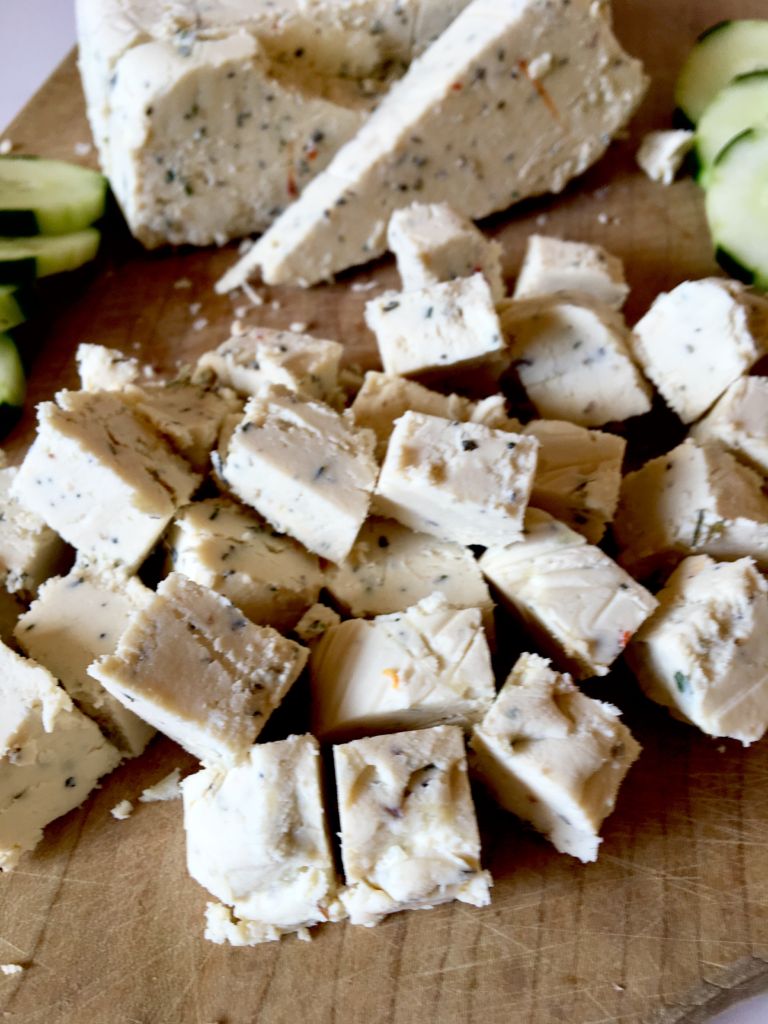 Chunks of vegan feta on a wooden board