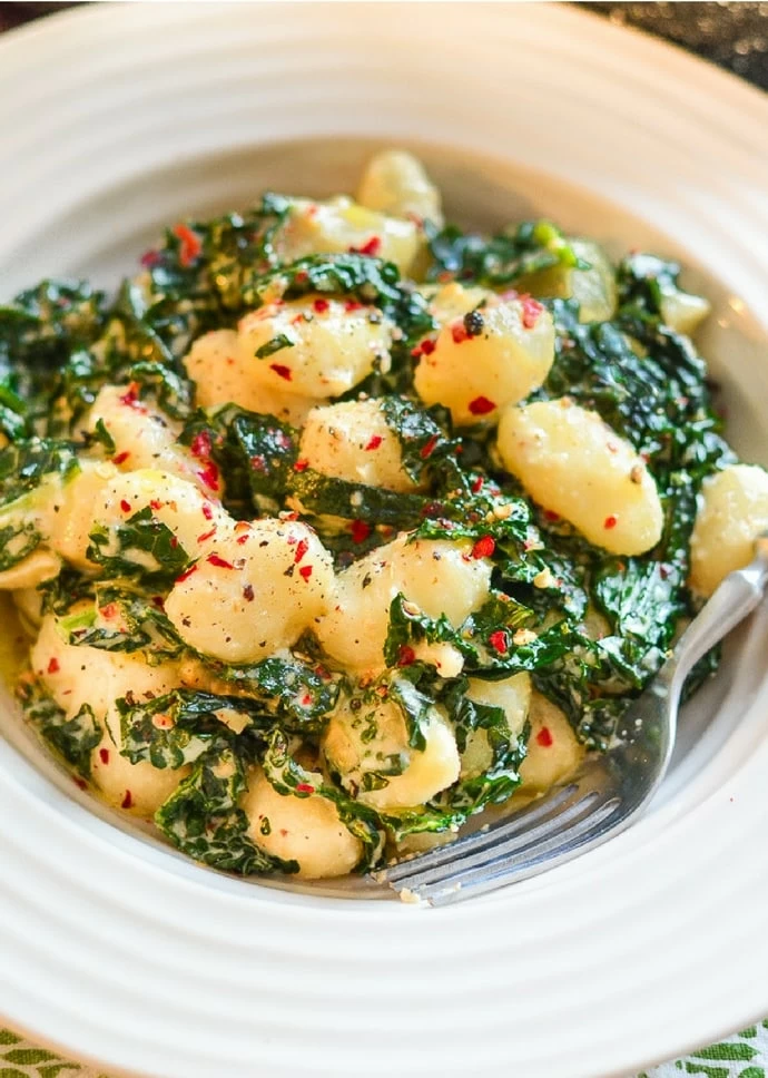 A bowl of vegan gnocchi with garlic and kale