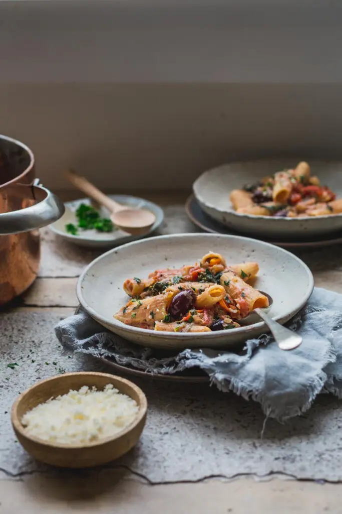 A table setting with two bowls of creamy tomato pasta