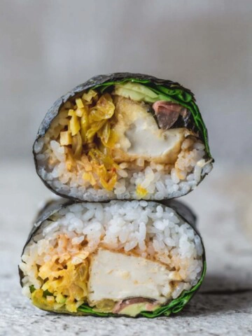 A close up of a sushi burrito on a board