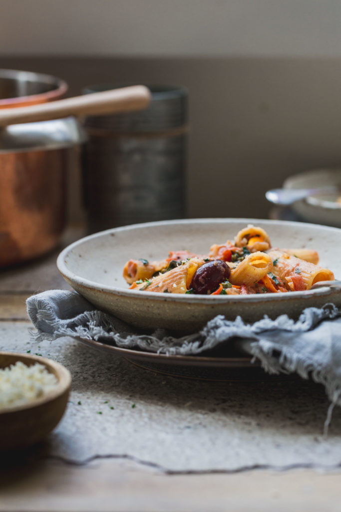 A single bowl of 1-pot creamy tomato vegan pasta on a rustic napikin