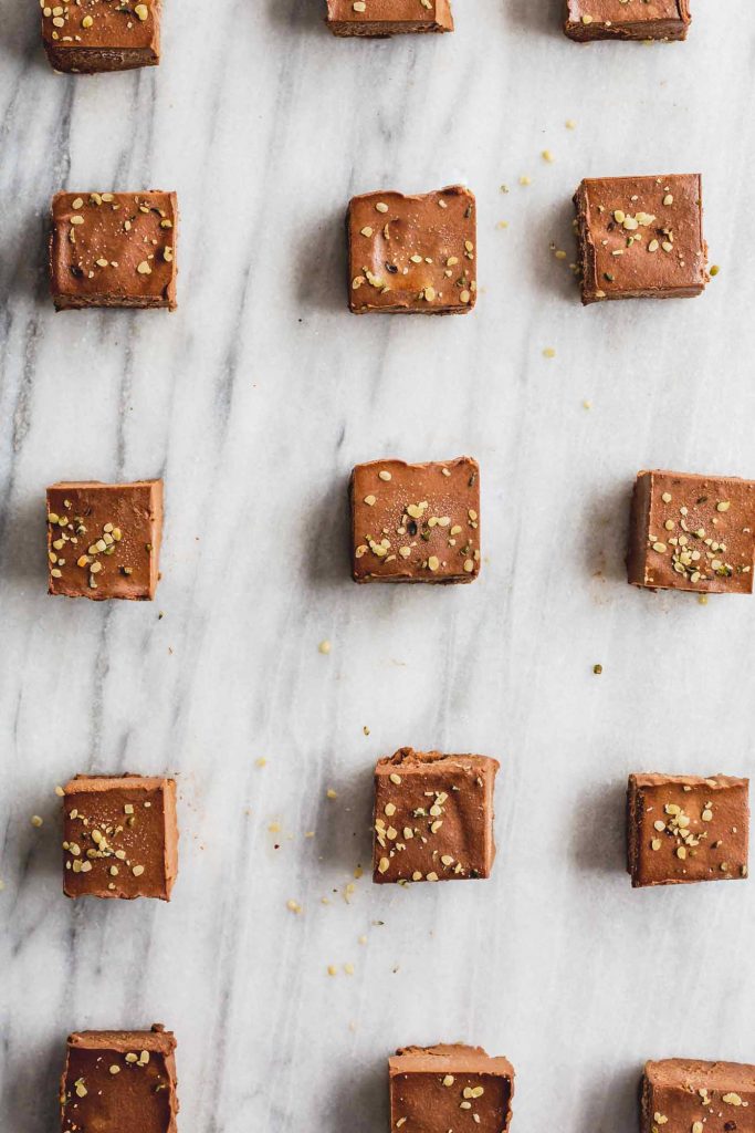 an overhead image of a grid layout of sweet potato chocolate squares on a marble background
