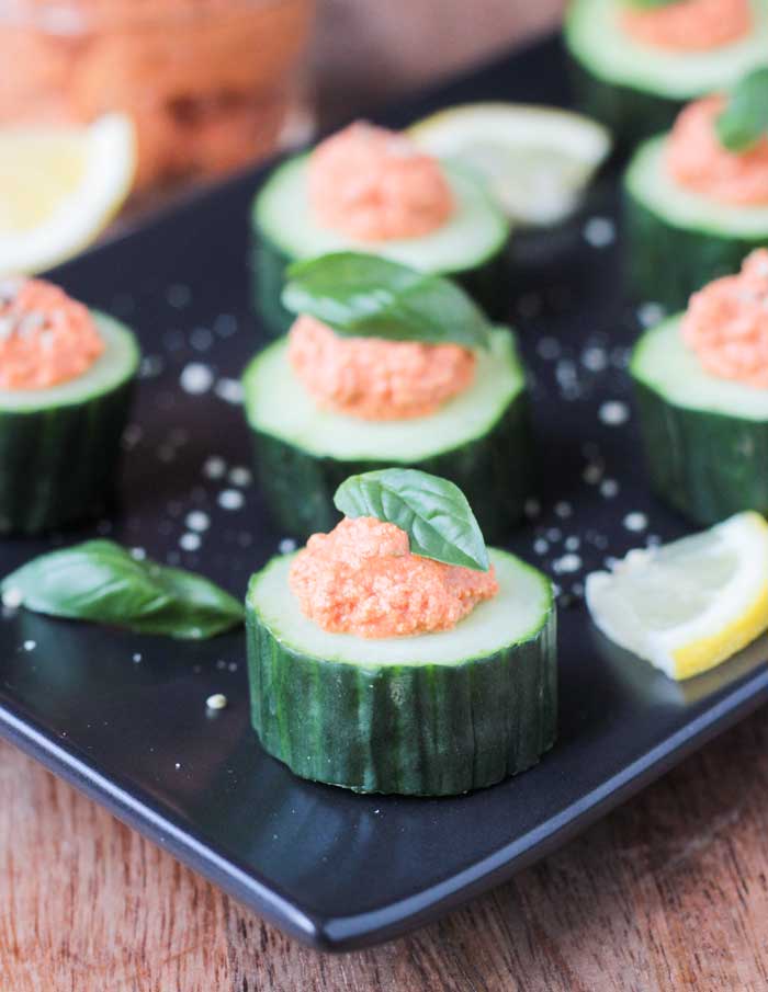 35 Vegan Party Food Recipes. No. 2 Cucumber Bites with Sun-dried Tomato Spread from Veggie Inspired on a black plate