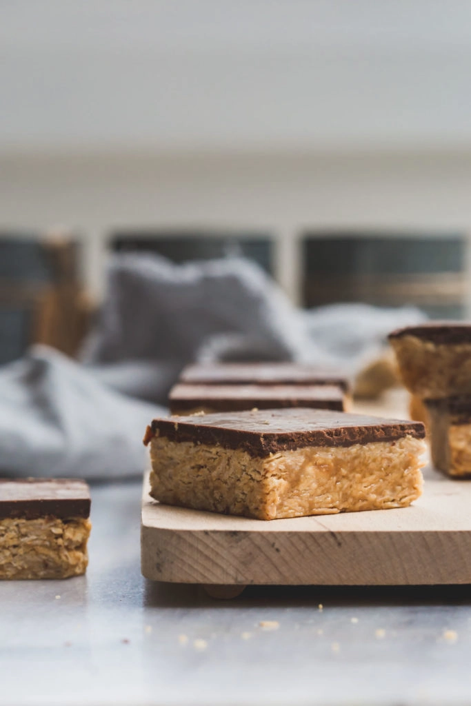 close up image of no-cook peanut butter and chocolate oat squares on a wooden board