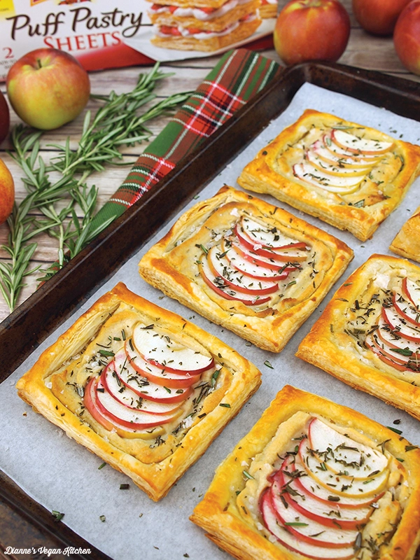 Vegan Apple and Cheese Tartlets from Dianne's Vegan Kitchen sitting on a lined baking tray with ingredients scattered around