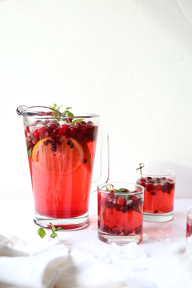 A jug and glasses of punch on a white background.