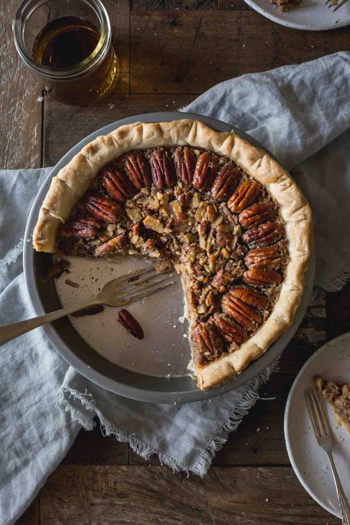 Close-up flat lay of cut into pecan pie in a pie pan