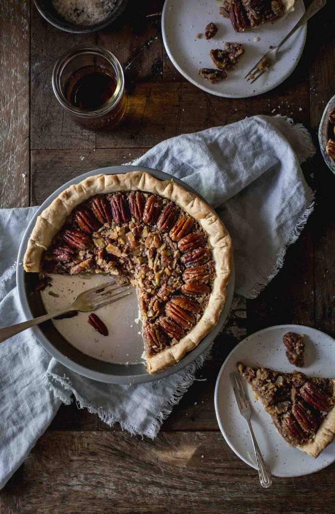 Flat lay image of cut into vegan pecan pie and served portions on plates