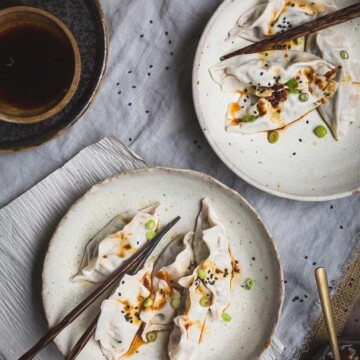 Two plates with kimchi dumplings and chopsticks