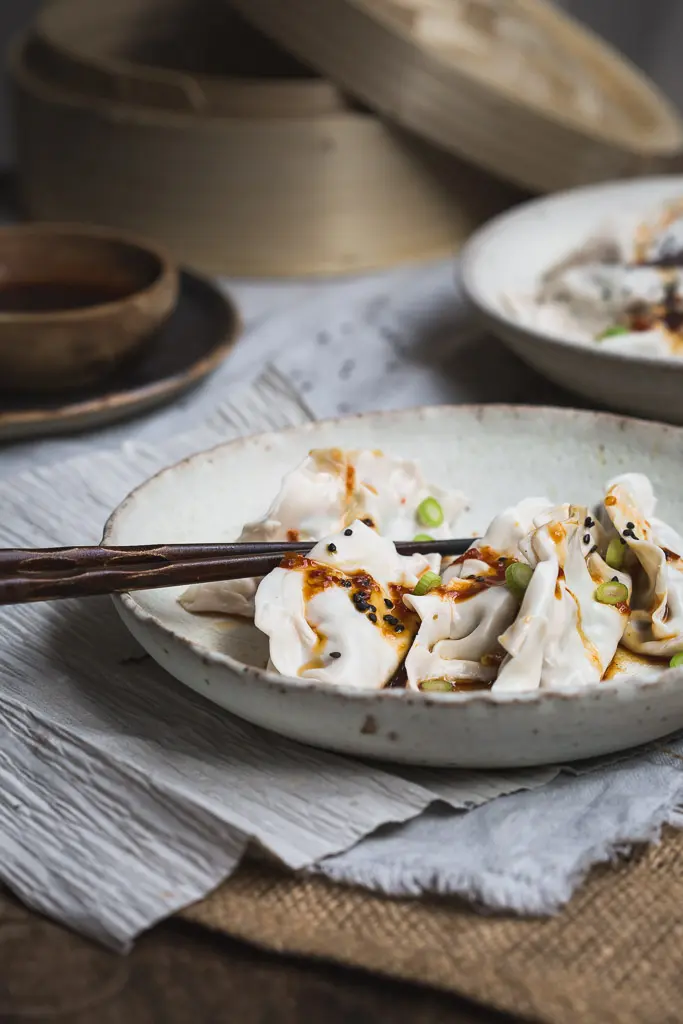 close up image of a bowl of steamed mushroom and kimchi dumplings