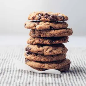 A stack of chocolate chip cookies on a striped napkin.