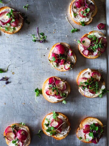 An overhead image of bagels with cream cheese and roasted radish