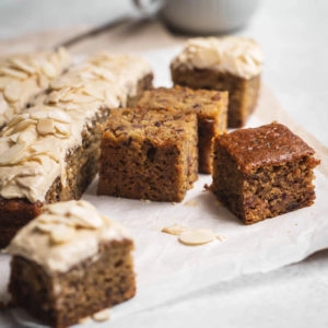 Slices of date cake on baking paper with frosting