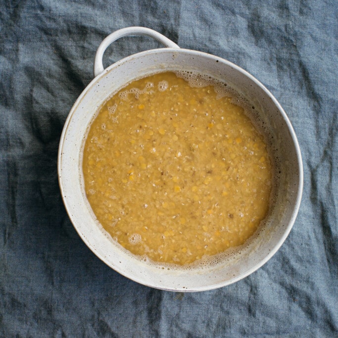 A bowl of soaking lentils on a cloth 