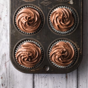 A cropped image of cupcakes with chocolate buttercream swirls