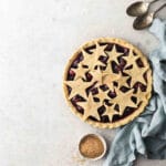 Unbaked pie sitting on a grey background with napkin.