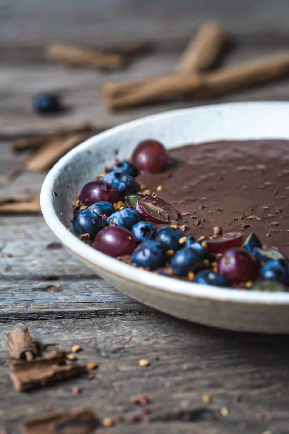 Chocolate chia pudding in a bowl with chopped berries.